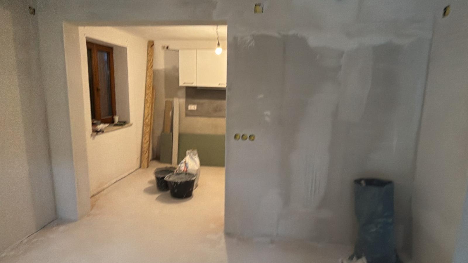 Wanddurchbruch Küche-Esszimmer nachher – neue rechteckige Öffnung, verputzt, Blick in die Küche